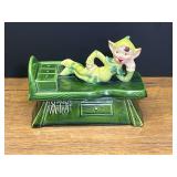 LR…vintage ceramic trinket box with a reclining pixie or elf on a green workbench. See pictures for details.