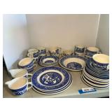Garage…Blue Willow patterned ceramic dishware, a highly recognizable style of blue-and-white transferware tableware. Includes bowls, dinner plates, cups and saucers, and bread plates, and creamers. 