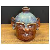 LR…Vintage southern folk art pottery face jug featuring a blue-grey crown glaze, prominent ears, and a single white tooth from Ila, Ga. See pictures for details.