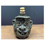 BR2…Southern folk art pottery face jug featuring a green glaze, large ears, a brimmed hat, and visible teeth. See pictures for details.
