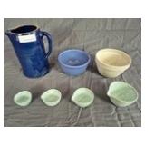 Group of ceramic kitchenware including one handled pitcher with dark blue glaze, two mixing bowls in