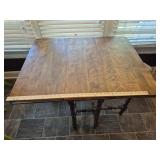 Wooden gate-leg table featuring two drop-leaf extensions and ornate spindle-turned legs with matchin