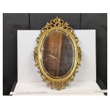 oval syroco style mirror with ornate gold frame