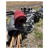 barrel of wood rods, tools, roll of mat, corner