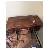 A singer, sewing table, sewing machine is not in