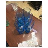 A blue glass set of cups and one green color cup