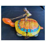 Tin Litho Islander Riding Turtle Toy