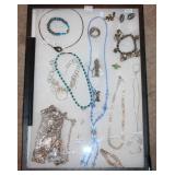 #56 Misc. necklaces in glass display case