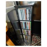 BLACK WOODEN SHELF WITH DOOR FILLED WITH CDS