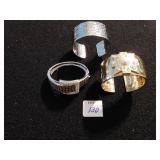 THREE GOLD TONE AND SILVER TONE CUFF BRACELETS