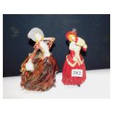 2 CHALK FIGURINES WOMEN HOLDING MUFFS 1 RED & 1