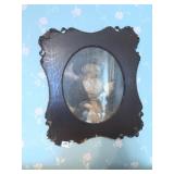 WOMAN READING PICTURE IN ORNATE BLACK FRAME,