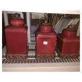 TWO RED CANNSTERS WITH LIDS ONE LID IS DAMAGED