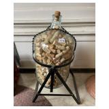 LARGE GLASS BOTTLE ON STAND W/ WINE CORKS