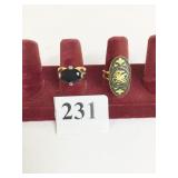 TWO GOLD TONE RINGS SIZE 7 BLACK STONE AND ETCHED