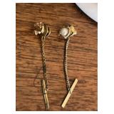 GOLD TIE TACK ON LEFT AND OTHER ON RIGHT
