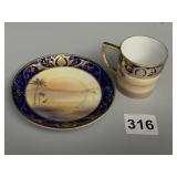 HEAVILY DECORATED DEMITASSE CUP AND SAUCER