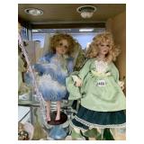 TWO PORCELAIN DOLLS ONE WITH GREEN DRESS AND