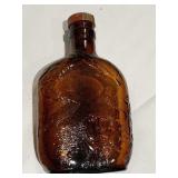 BROWN BOTTLE WITH MAN ON FRONT