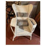 ANTIQUE WICKER CHAIR WITH BOLSTER CUSHION