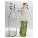TWO OLIVE OIL BOTTLE WITH LIDS ONE STILL HAS
