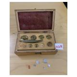 BRASS SCALE WEIGHTS SIX WITH PAIR OF TWEEZERS IN