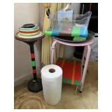 PINK METAL SIDE TABLE WITH ITEMS ATTACHED TO IT,