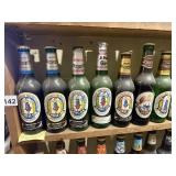 ASSORTED BEER BOTTLES AND SOME CANS MOST FULL