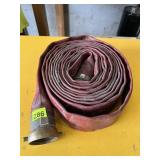 RED ROLLED FIRE HOSE W/ METAL COUPLINGS.