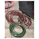ASSORTED GARDEN HOSES, RED/BROWN & GREEN COILED.