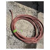 REDDISH-BROWN COILED GARDEN HOSE.