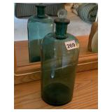 GREEN GLASS BOTTLE W/ CLEAR GLASS STOPPER.