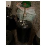 GLASS CARBOY W/ AIRLOCK, FILLED W/ DARK LIQUID.