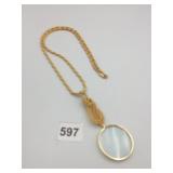GOLD-TONE METAL MAGNIFYING GLASS PENDANT, ROPE