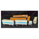 3 TOY TRACTOR TRAILERS AND 1 TOY BUS