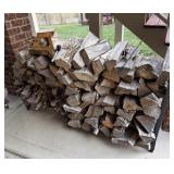 STACK OF SEASONED FIREWOOD ON A METAL RACK