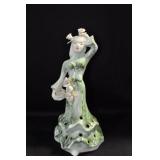 LADY IN GREEN WITH ROSES ON HER HEAD AND A BOWL