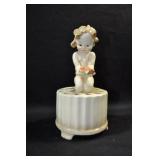 BABY HOLDING FLOWERS - 6 1/2" - TAN MARKED: U.S.