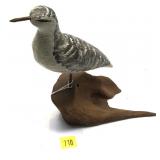 Wooden carved shorebird on driftwood