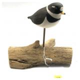 Wooden carved shorebird on driftwood
