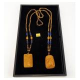 Lot, 2 orange necklaces with carved pendants
