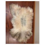 Faux fur rug with soft plush texture and animal hide-style shape. Measures approximately 48 in. long. Decorative accent rug suitable for bedroom, sitting area, cabin décor, or display.