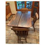 Antique child’s farmhouse table with four matching chairs. Table measures approximately 27 in. tall x 48 in. long x 31 in. wide. Chair seat height is approximately 16 in. Features painted wood const