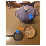 Cast iron cookware group including a Lodge lidded pot and two unmarked mini skillets. Suitable for cooking, baking, serving, camping, or collecting.