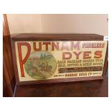 Putnam Dyes countertop display cabinet with advertising graphics. Compact wooden cabinet with front display panel and divided interior storage. Measures approximately 10 in. tall x 21 in. wide x 9 in.