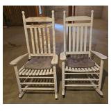 2 white rocking chairs in need of fresh paint job