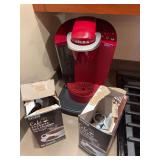 Keurig single-serve coffee maker with assorted coffee pods. Countertop coffee brewing group suitable for kitchen, office, break room, dorm, or general household use.