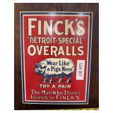Reproduction Finck’s Overalls porcelain sign with vintage-style advertising graphics. Decorative workwear and general store advertising piece suitable for display in a shop, garage, office, or colle