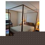 Full-size four-post bed frame with memory foam mattress. Features traditional wood construction with turned posts and matching headboard and footboard. Includes bed frame components and mattress.Locat