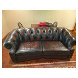 Seven Seas leather sofa with rolled arms, nailhead trim, and carved wood accents. Measures approximately 35 in. tall x 88 in. wide x 44 in. deep. Please review photos for condition, wear, and details.